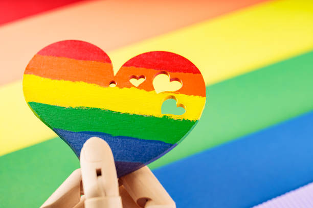 istock Artificial arm holds rainbow heart on multicolored lgbt flag. LGBT Pride month concept 1497275719