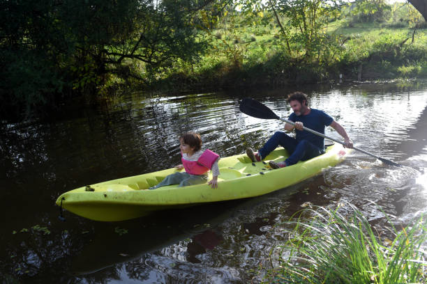 Red and black kayak moored against a wooden jetty on the River Lea, with calm water and natural surroundings creating a peaceful riverside scene.