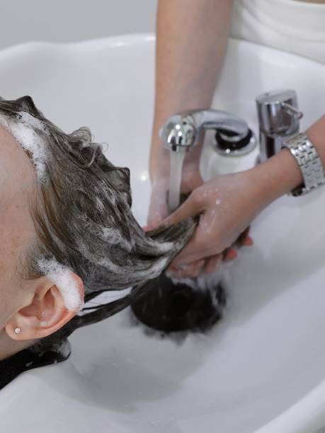 istock hairdressing process: washing hair with shampoo, making head massage 1497283185