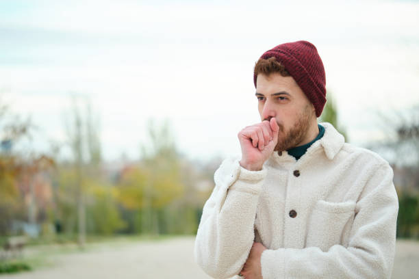 Latin young man coughing during winter, flu. stock photo