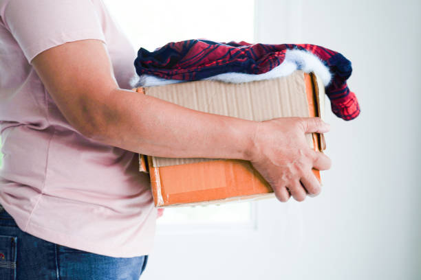 istock Clothes donations in cardboard box for volunteer. 1497288430