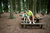 Father and son using a digital tablet in the forest