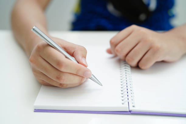 istock Asian teenage student write homework, study lesson for exam online learning education. 1497289697