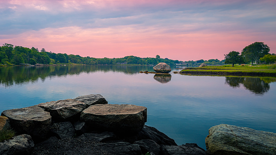 Sunrise over the lake with glacial rocks. Tranquil morning landscape in coastal New England.