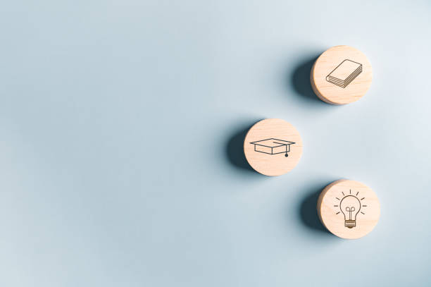istock Education graduated icon on wooden block with mortarboard Graduation cap book lightbulb on blue background. Students getting ready to return to college arrive first time in school. Off to University 1497292268
