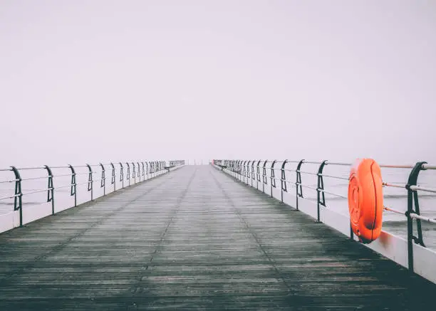 An empty pier in the North Yorkshire seaside town of Saltburn-by-the-Sea on a misty day.