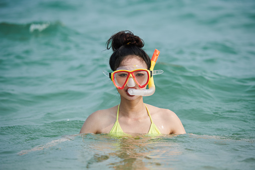 Happy young woman enjoying snorkeling on sea