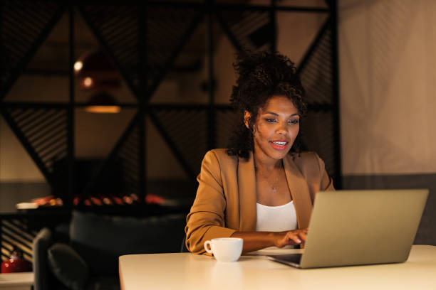 istock Focused African woman, working overtime, at the office, using a laptop. 1497300693
