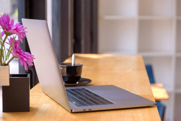 istock Laptop computer on wooden table with coffee cup and flower. 1497301369
