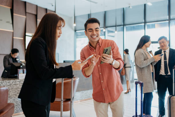 istock Asian business people using smartphone and having conversation at hotel lobby 1497305221