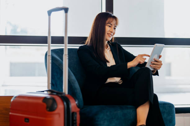 istock Asian businesswoman using digital tablet at hotel lobby 1497305227