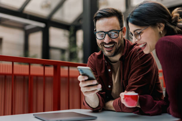 istock Smiling business people sitting at the office, looking at the mobile phone, using it. 1497307056