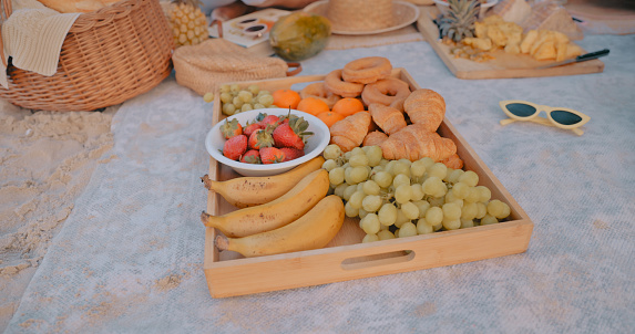Food, fruit and tray at a picnic for a celebration, party or romantic date outdoor at the beach. Nutrition, wellness and delicious healthy snacks for friends at an event by the ocean in summer.