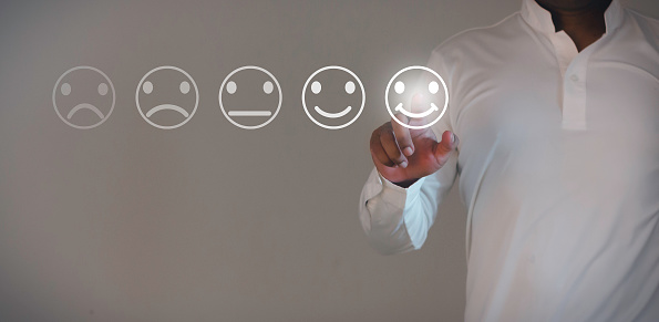Business people are touching the virtual screen on the happy face icon to give satisfaction in service. Customer service and Satisfaction concept.