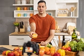 A male social media influencer creates videos, shares instructions for making fruit salad online, expands his subscriber and advertising-generating audience. Start-up options for new small businesses