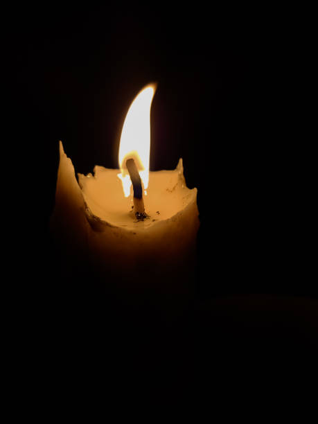 istock a candle lit at night against a black background 1497312183