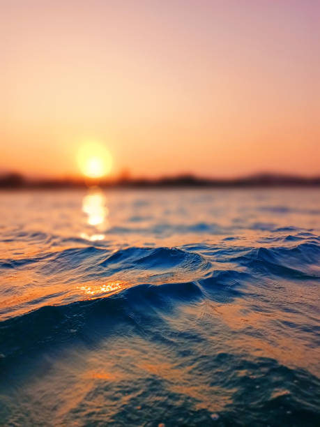 istock Sea wave splash, sunset blurred bokeh background, ocean water surf ripple texture, sunrise soft focus, tropical island beach dawn, sundown orange sun shine reflection, summer holiday, vacation, travel 1497315479