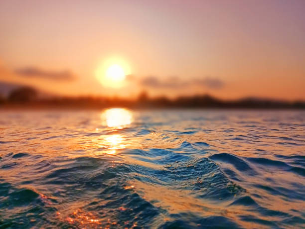 istock Sea wave splash, sunset blurred bokeh background, ocean water surf ripple texture, sunrise soft focus, tropical island beach dawn, sundown orange sun shine reflection, summer holiday, vacation, travel 1497315483