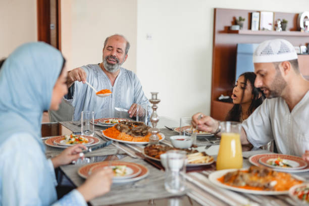 istock Middle Eastern Grandfather Smiling While Putting Food On Plate 1497318169