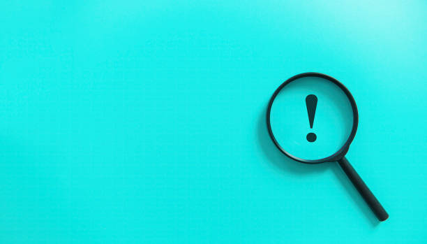 istock Magnifier magnifying exclamation mark on blue background. Alert and caution concept. 1497318894