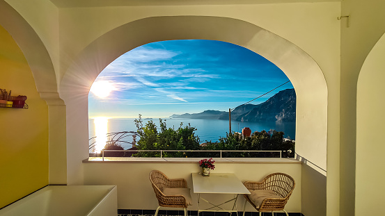 Panoramic sea view from luxury apartment on the Mediterranean Sea. Terrace balcony with arch overlooking the coastline in Praiano, Amalfi Coast, Campania, Italy, Europe. Summer vacation vibes. Awe