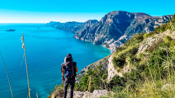 istock Praiano - Man with backpack enjoying scenic view from hiking trail between Positano and Praiano at the Amalfi Coast, Campania, Italy, Europe 1497327002