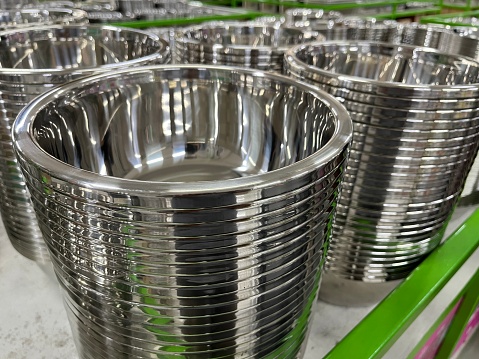 Many stacks of metal bowl with various size in a supermarket for sale