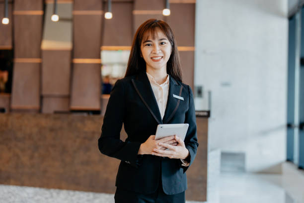 istock Asian female hotel manager smiling and looking at camera 1497330547