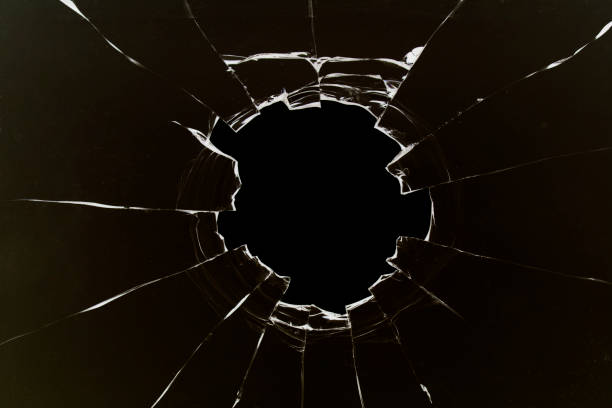 istock Hole in the glass, broken window with cracks texture. Effect of broken transparent glass. 1497335716