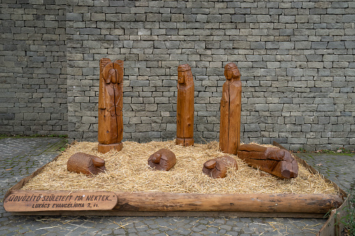 Szentendre, Hungary - November 30th, 2022: Wooden sculptures make up a nativity scene in a church yard in the hungarian village Szentendre.