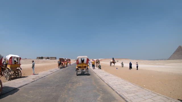 Slow motion of the road to the pyramids with hose pulled vehicles and crowd of tourists