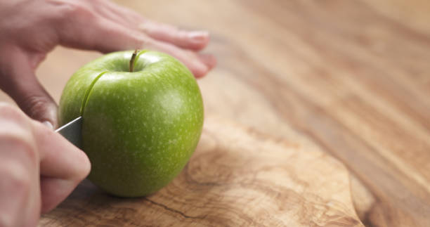 istock young female hands cut green apple into halves 1497346826