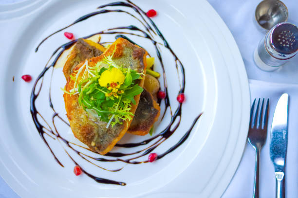 istock Crispy pan fried sea bass fillet with pomegranate seeds as decor 1497348002