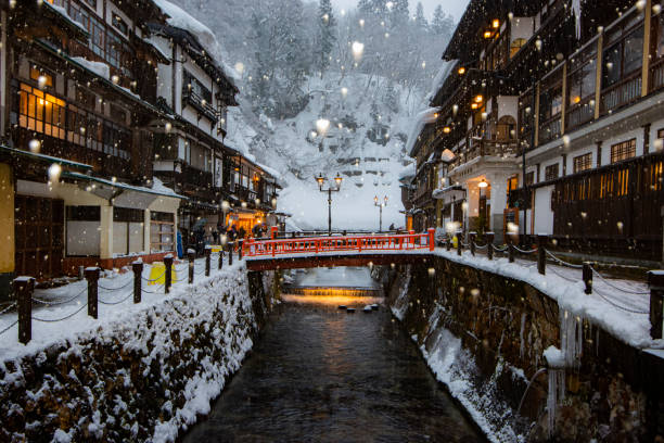 Illumination of Ginzan Onsen in Winter, Yamagata, Japan Japan - January 30, 2022 : Scenic view of Old Hot Spiring Accomodation in Winter with Illumination in the evening, Ginzan Onsen is most famous Hot Spring in Yamagata, Japan honshu stock pictures, royalty-free photos & images