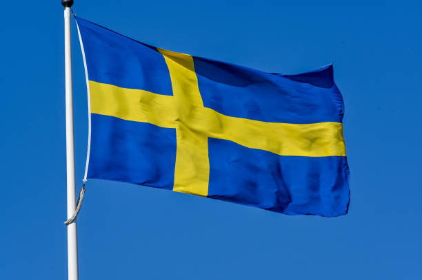 istock Swedish flag on flag pole and clear blue sky 1497348114