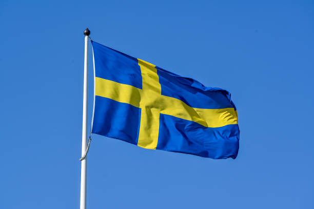 istock Swedish flag on flag pole and clear blue sky 1497348204