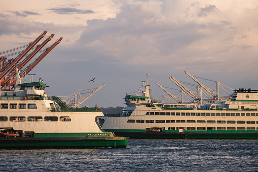 Seattle, USA - May 15, 2023: Elliott Bay late in the day as a Ferris approach and depart the new Colman dock late in the day.