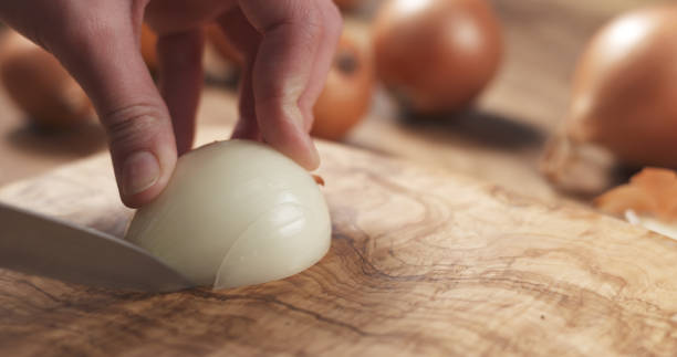 istock young female hands slicing white onion 1497352455