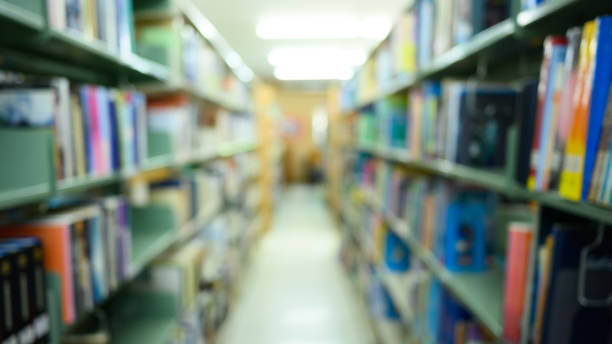 istock Blurred public library interior with aisle of bookshelf with textbooks 1497352795