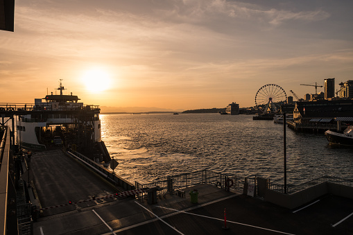 Seattle, USA - May 3, 2023: Elliott Bay late in the day as a Ferry approaches the new Colman dock at Sunset.