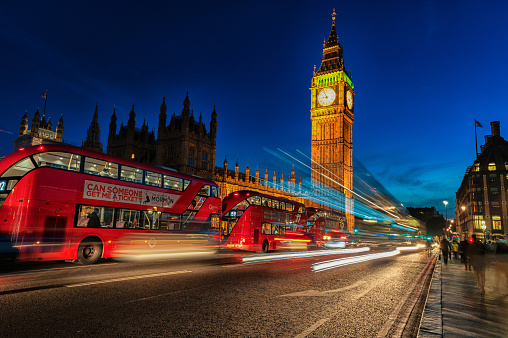 London, England - August 22, 2016: London Big Ben and Westminster Bridge with Palace of Westminster. Blurry people because of Long Exposure. Red bus in Motion. England, UK