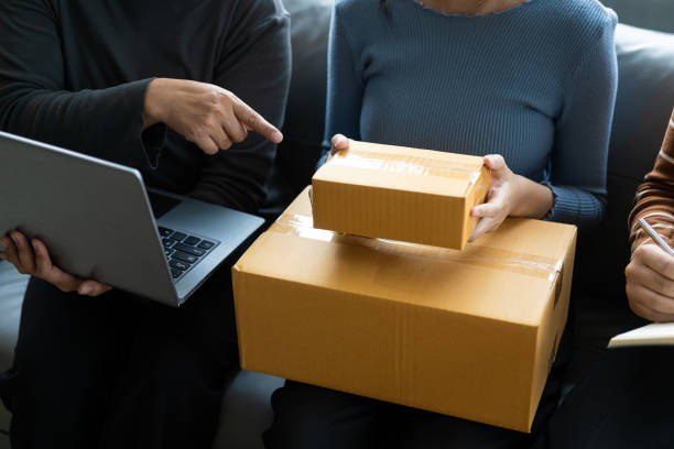 Online store woman holding parcel e-commerce packing post shipping box order inspection online retail store in warehouse delivery service SME business idea