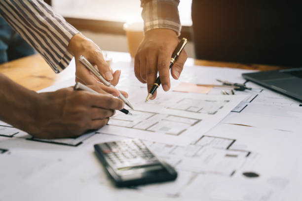 istock Person's engineer Hand Drawing Plan On Blue Print with architect equipment, Architects discussing at the table, team work and work flow construction concept. 1497366195