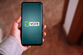 Woman use smartphone to vote online. Political concept.