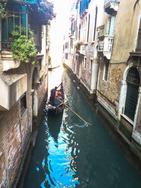 мужчина плывет по каналам венеции, италия - gondola venice italy canal sailor стоковые фото и изображения