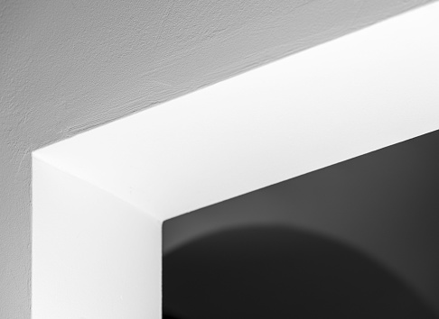 A small white wall illuminated against a dark background