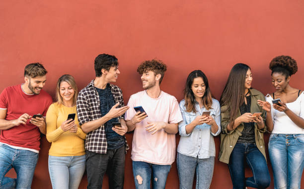 istock Young friends using mobile smartphone outdoor - Millennial generation having fun with new trends social media apps - Youth technology people addicted - Red background 1497387188