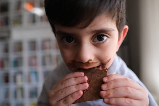 Close up of cute little boy eating chocolate