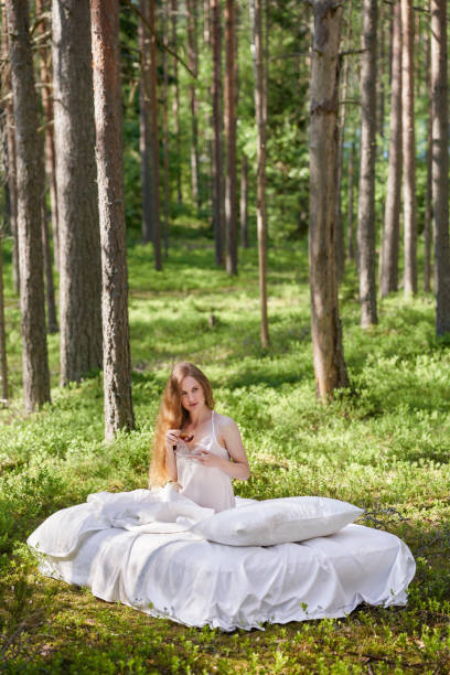 istock Young woman wakes up in a summer forest 1497391666