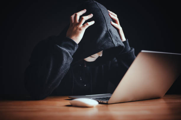 istock Hackers frustrated upset and hold temples head by two hands to tricking victims transferring money or hacking personal data laptop computer. Cybersecurity unsuccessful illegal black hat hacker hoodie. 1497395421